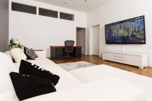 纽约4 Bedroom NYC Apartment的客厅配有白色沙发和平面电视。