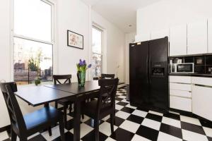 纽约4 Bedroom NYC Apartment的厨房配有桌椅和黑冰箱。 更多24张照片