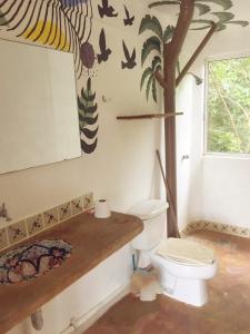 baño con aseo y árbol en la pared en Casa Macondo, en Puerto Ángel