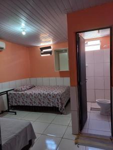 um quarto com uma cama e uma casa de banho com um espelho. em Pousada Kaka em Teresina