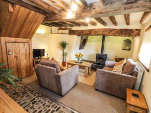 a living room with two chairs and a fireplace at Ty Tabitha Wynne in Caerwys