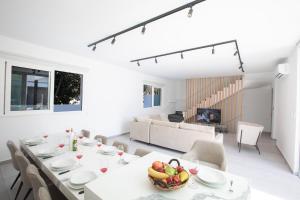 a white dining room with a table and chairs at Kube Luxury Villas in Ayia Napa