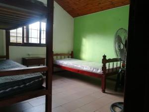 um quarto com 2 beliches e uma parede verde em Casa cómoda en Barra del Chuy, Uruguay em Barra del Chuy