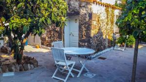 une table bleue et deux chaises devant un bâtiment dans l'établissement Bon Bon, à Milis