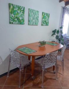 une table en bois avec des chaises et des peintures murales dans l'établissement Bon Bon, à Milis