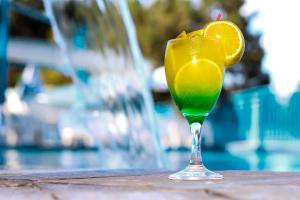 a drink with an orange slice in a glass at Hotel Vilage Inn All Inclusive Poços de Caldas By Nacional Inn in Poços de Caldas