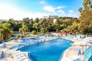 a large swimming pool with chairs and a resort at Hotel Vilage Inn All Inclusive Poços de Caldas By Nacional Inn in Poços de Caldas