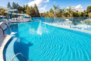 a large blue swimming pool with a fence at Hotel Vilage Inn All Inclusive Poços de Caldas By Nacional Inn in Poços de Caldas