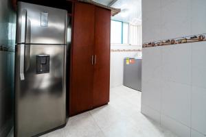 圣玛尔塔Amplio apartamento frente a la playa El Rodadero的房间里有带不锈钢冰箱的厨房