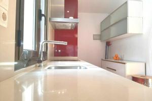 モンソンにあるÁtico en Monzónのシンクと窓のある白いキッチン