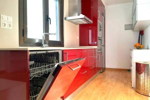 a kitchen with red cabinets and a dishwasher at Ático en Monzón in Monzón