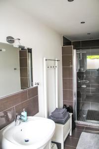 een badkamer met een witte wastafel en een douche bij Ferienwohnung-Heinke-Urlaub-in-Tating-nahe-St-Peter-Ording in Tating