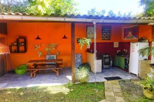 Casa de color naranja con mesa y cocina en Biergarten Hostel, en Abraão