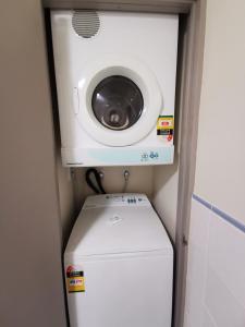 a washing machine sitting on top of a washer and dryer at The Anchorage Apartments in Mount Maunganui