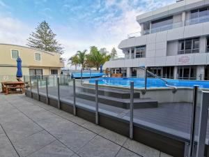 uma piscina em frente a um edifício em The Anchorage Apartments em Mount Maunganui