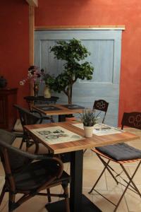 a dining room with a wooden table and chairs with plants at La Villanelle maison d'hôtes in Pelousey
