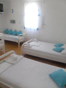 2 camas en una habitación con almohadas azules en Princess Santorini Villa, en Perissa