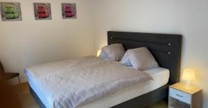 1 dormitorio con 1 cama con cabecero negro en Ferienwohnung Chirchgass en Meiringen