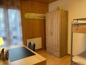 Habitación con cama, armario y escritorio. en Ferienwohnung Chirchgass en Meiringen