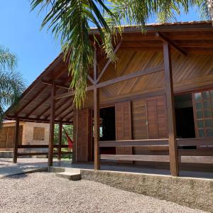 a house with a wooden facade with a palm tree at Costa Montana in Louro Müller
