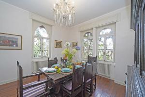 Un comedor con una mesa y una lámpara de araña. en Villa Maria, en Saló