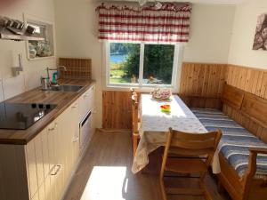 eine Küche mit einem Tisch, einem Waschbecken und einem Fenster in der Unterkunft Fritidshus House by the lake in Mjölby
