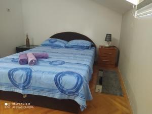 ein Schlafzimmer mit einem Bett mit lila Schuhen darauf in der Unterkunft Apartmani Marić In in Vrnjačka Banja