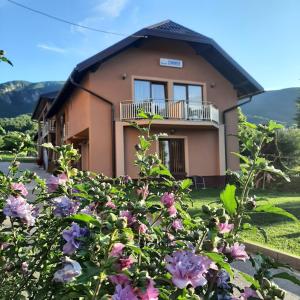 a house with flowers in front of it at Rooms Marijanović Plitvice in Vrelo Koreničko