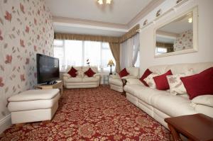 a living room with a white couch and a television at The Bayridge Guest House in Bridlington