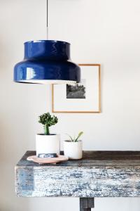 a blue pendant light over a wooden table with two plants at Hotel June Malibu in Malibu