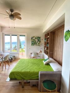 a bedroom with a large green bed and a table at CaseMaggi Sea View Terrace in Portovenere