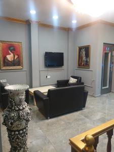 uma sala de estar com um sofá e uma televisão de ecrã plano em Stad Pansiyon AİLE em Istambul