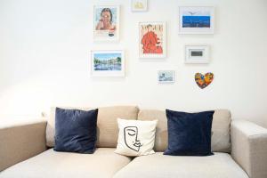 a couch in a living room with pictures on the wall at Bright Chelsea Garden Nest in London
