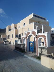 un gran edificio con una puerta azul delante de él en Princess Santorini Villa, en Perissa