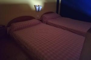 2 Betten in einem kleinen Zimmer mit rosa Bettwäsche in der Unterkunft Casa Pla de la séquia - Xaló in Jalón