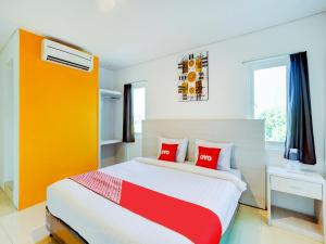 a bedroom with a large bed with red pillows at LG Hotel Jember in Berpodak