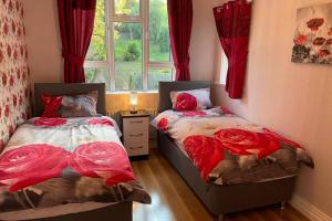 two beds in a room with a window at Glenmount Castleblayney in Castleblayney