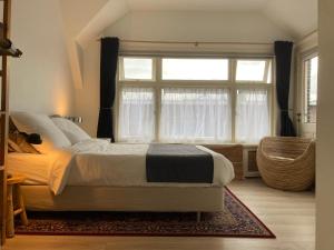 a bedroom with a bed and a large window at Rooftop View in Utrecht