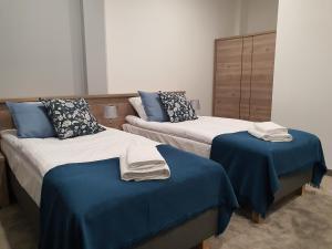 2 camas en una habitación con sábanas azules y toallas en Hotel Garbów *** Centrum Konferencyjno - Bankietowe, en Garbów
