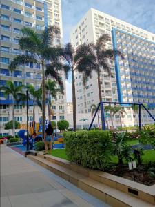 una persona caminando por un parque con palmeras en Vangie's Place at SEA RESIDENCES, en Manila