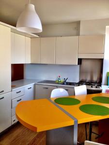 a kitchen with a yellow table and white cabinets at Casa Romea in Cividale del Friuli