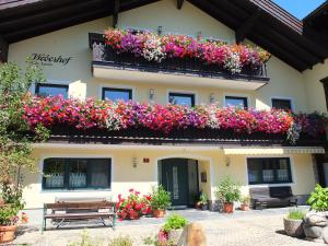 Ein Gebäude mit einem Blumenstrauß auf dem Balkon in der Unterkunft Haus Schön Weberhof in Kirchbichl