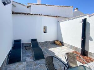 un patio avec des chaises et une table dans un bâtiment dans l'établissement Casa La Aduana, à Montejaque