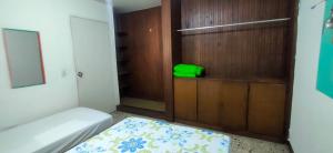 a small bedroom with a bed and a wooden wall at Hostal Rich in Medellín