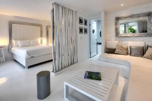 Le Cameleon Boutique Hotel في بويرتو فيجو: غرفة معيشة مع سرير وأريكة