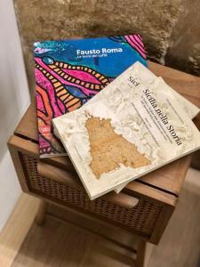 カステッランマーレ・デル・ゴルフォにあるLoft Incantevole Castellammare del Golfoの本と食べ物の入った袋が置かれたテーブル +4枚の写真
