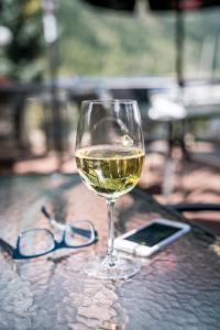 a glass of white wine and glasses on a table at Prestige Inn Nelson in Nelson
