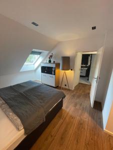 a attic bedroom with a bed and a kitchen at MYSTAY BERLIN Müggelheim in Berlin