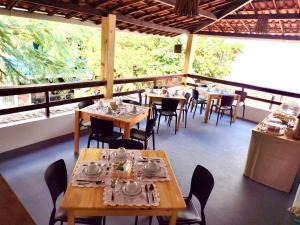 a restaurant with wooden tables and chairs and windows at Pousada Nativa Jeri in Jericoacoara