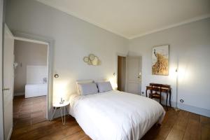 a bedroom with a large white bed and a bathroom at Le Twelve in Angoulême